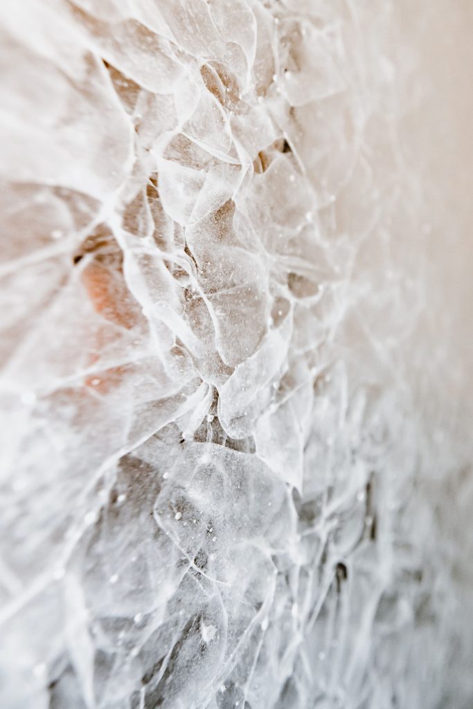 Eine Nahaufnahme einer weißen Wand, die mit Eis bedeckt ist.